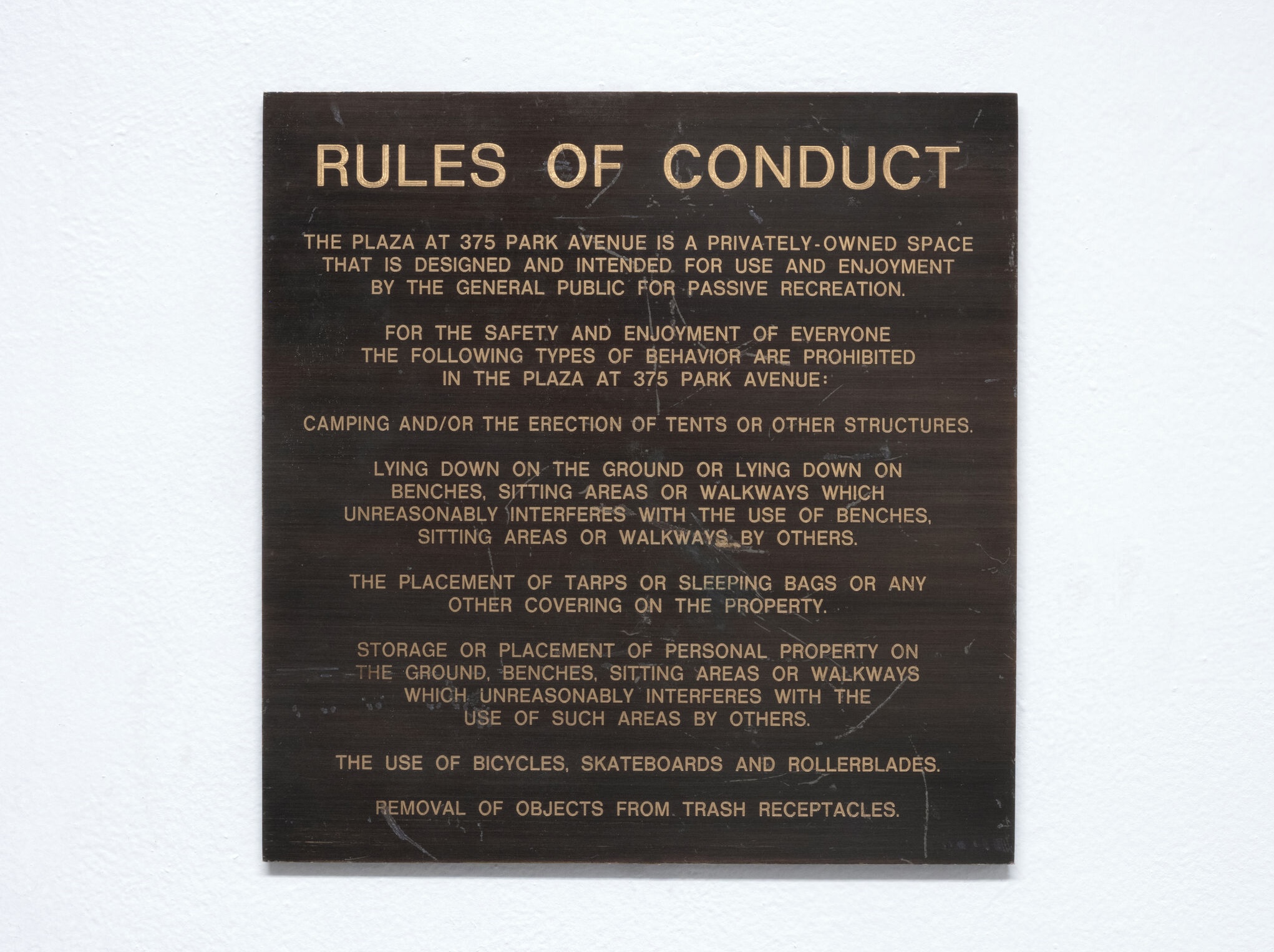 color photo of square metal sign with codes of conduct for 375 Park Avenue